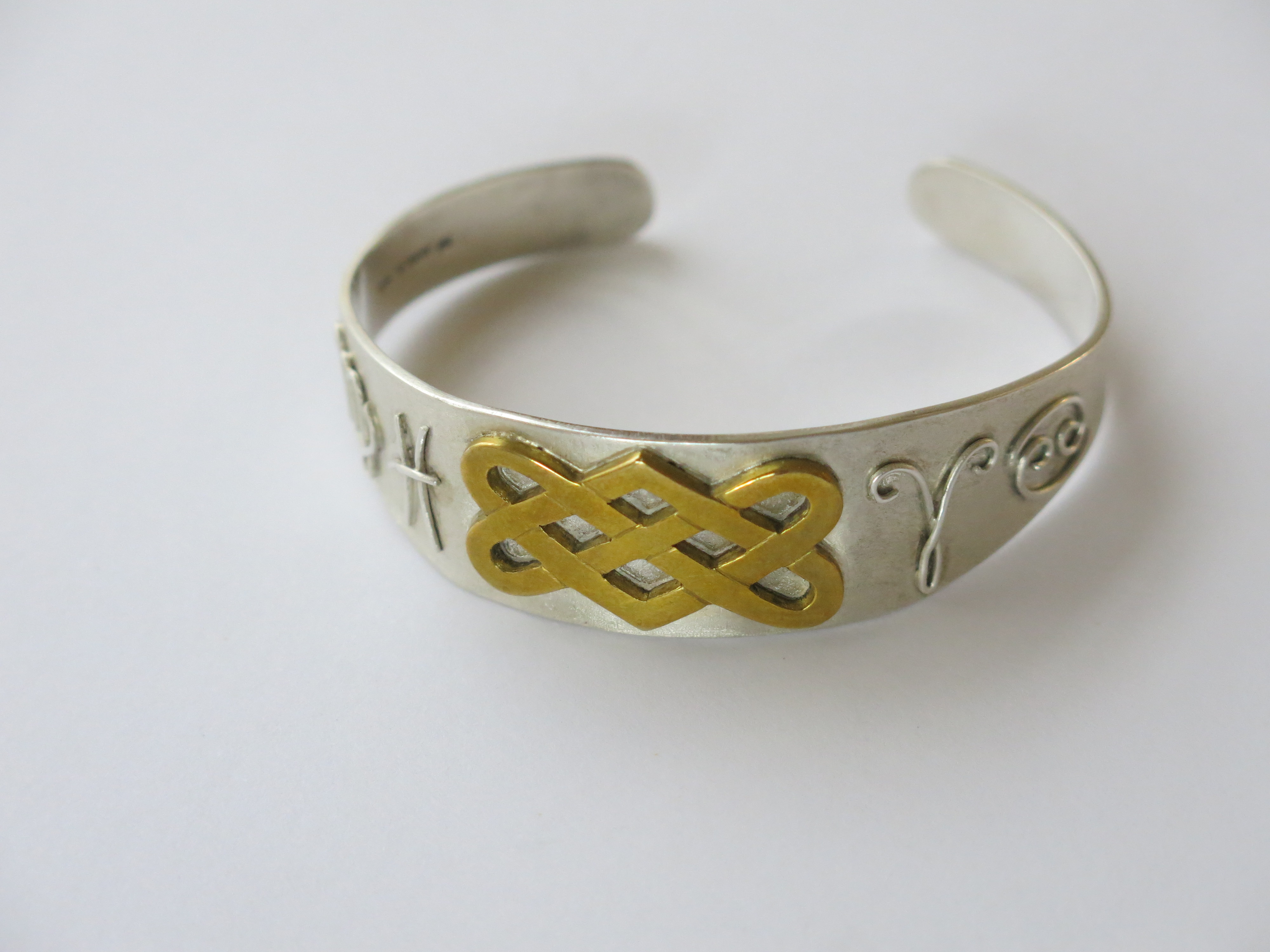 Silver bangle with brass knotwork design