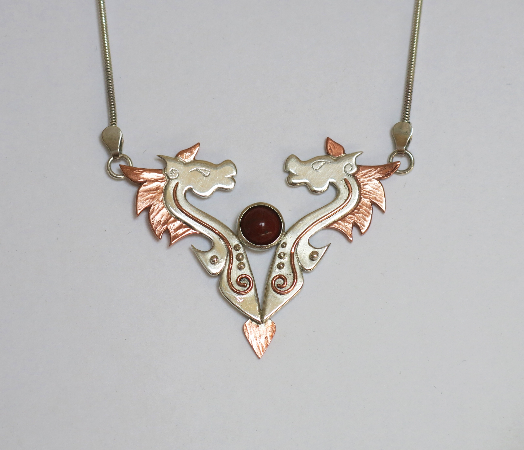 Silver and copper horses with carnelian